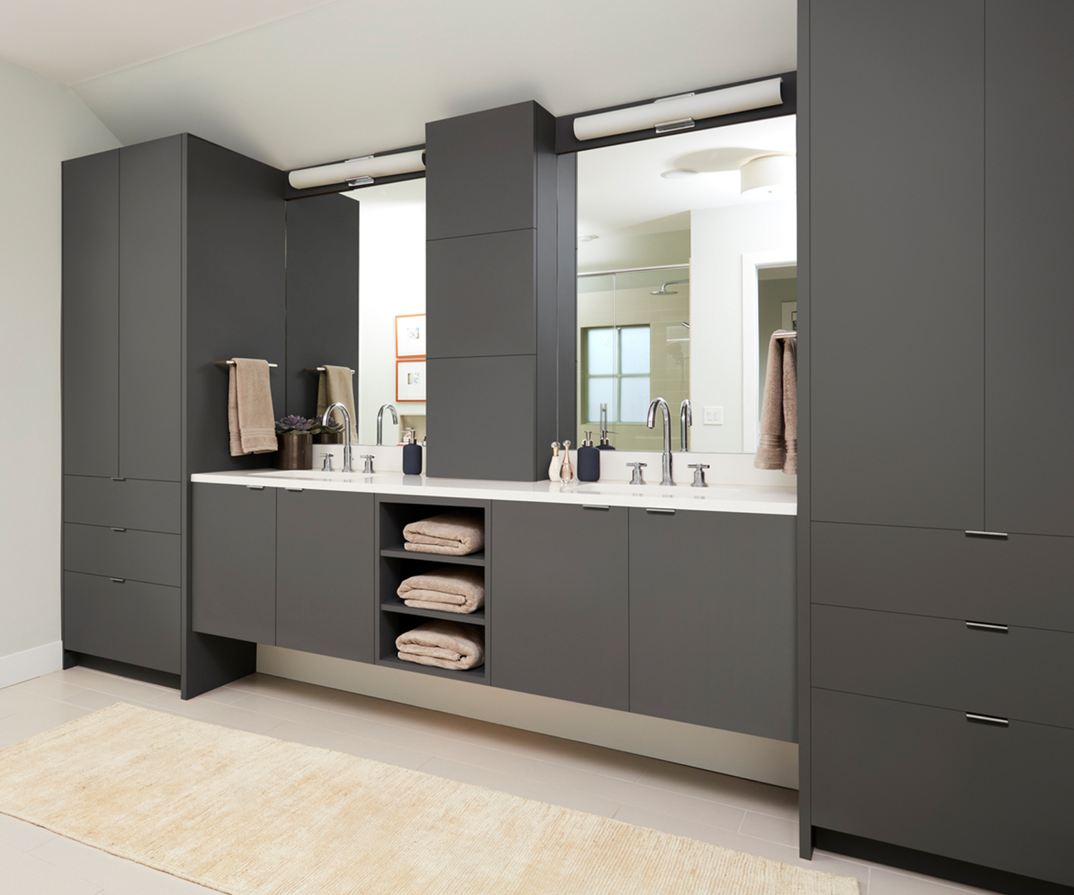 Seen from another angle, the contrast between dark gray FENIX NTM Grigio Londra cabinets and white surfaces and bathtub.