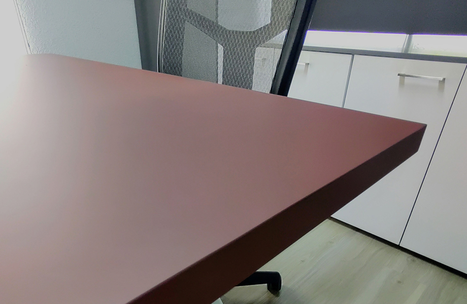 Approach to the table in the LADE boardroom with FENIX Rosso Jaipur application and chair 