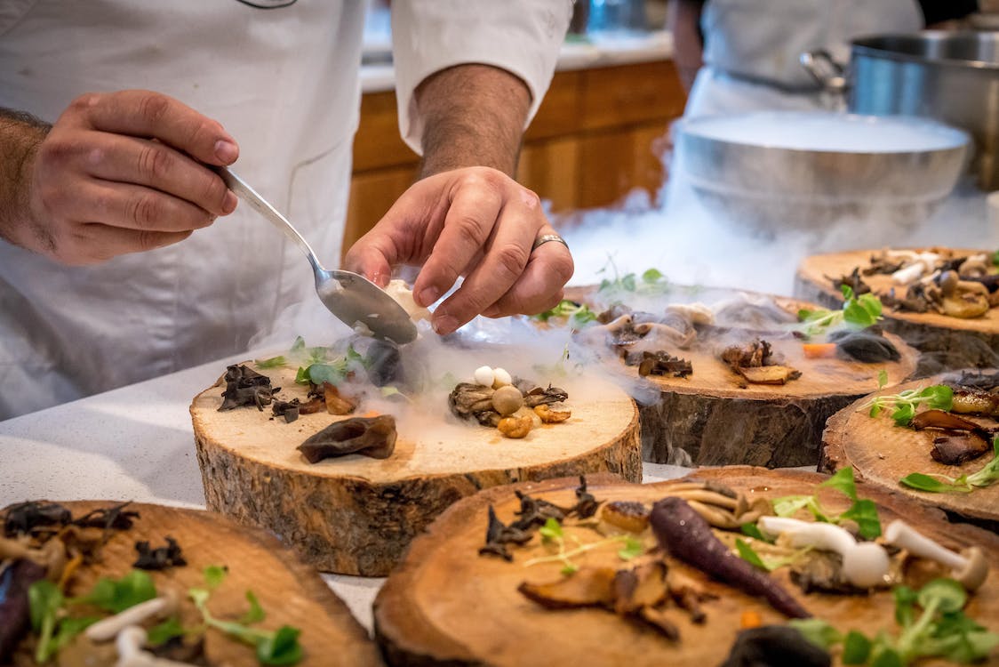 chef plating up food in a commercial kitchen 