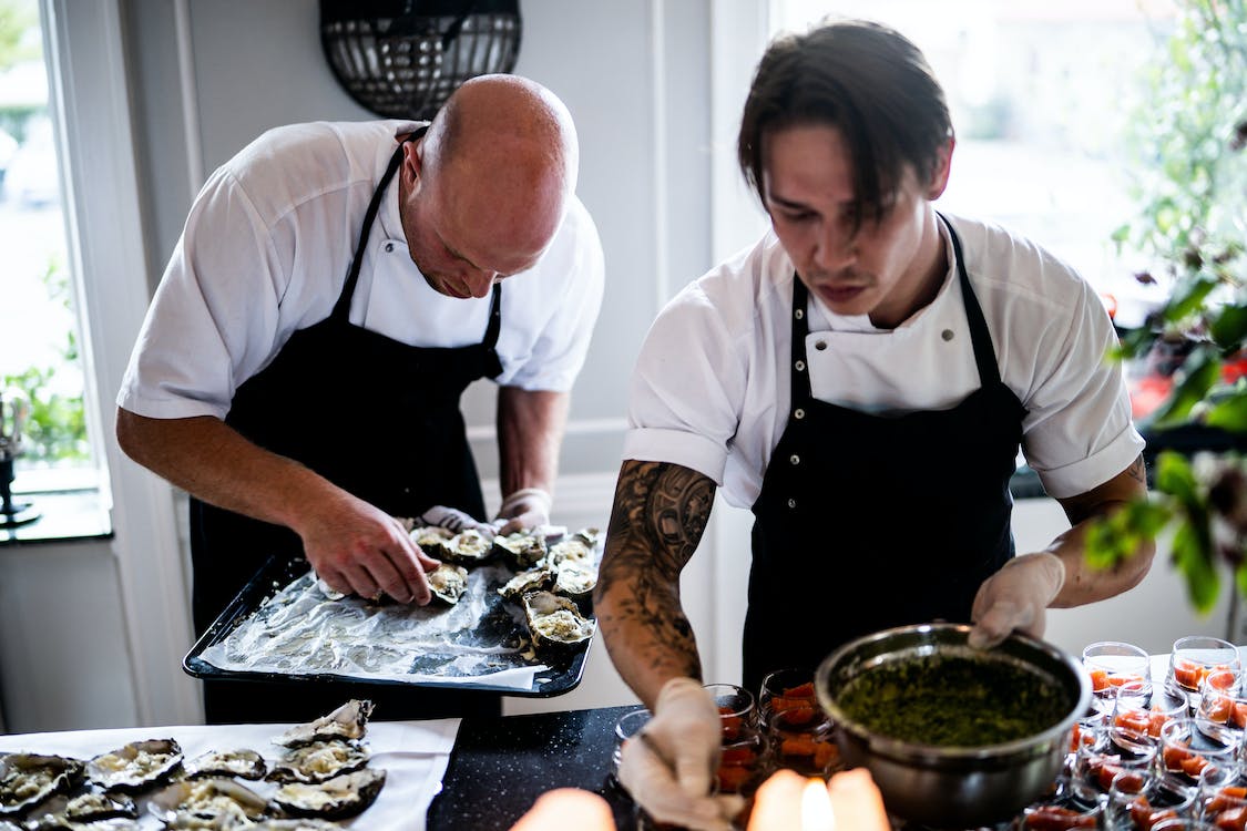 two chefs plating up in a kitchen 