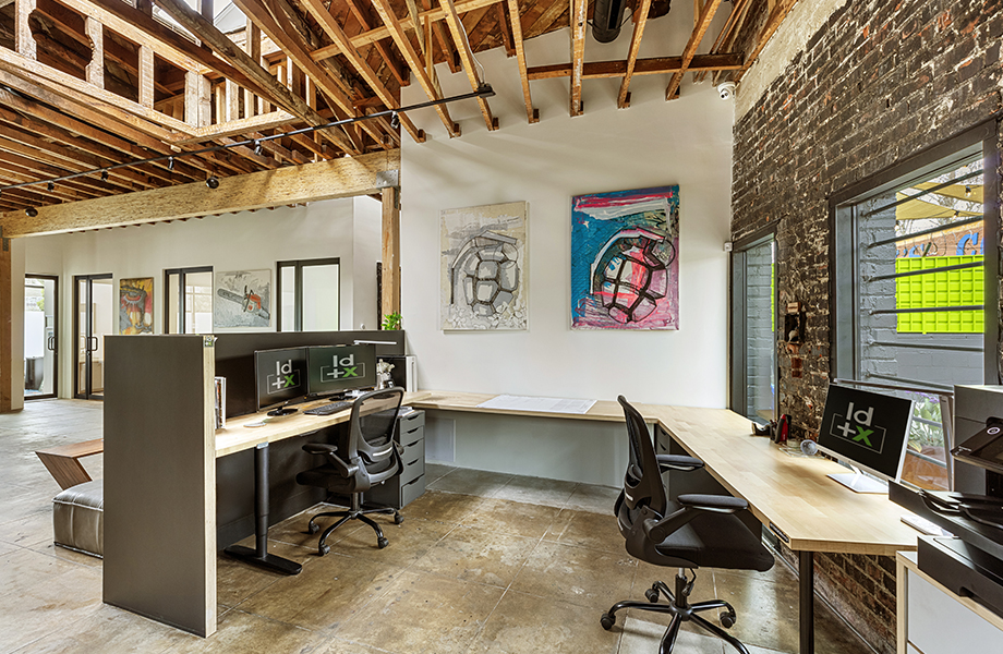 Office desk with artwork and exposed beams overhead