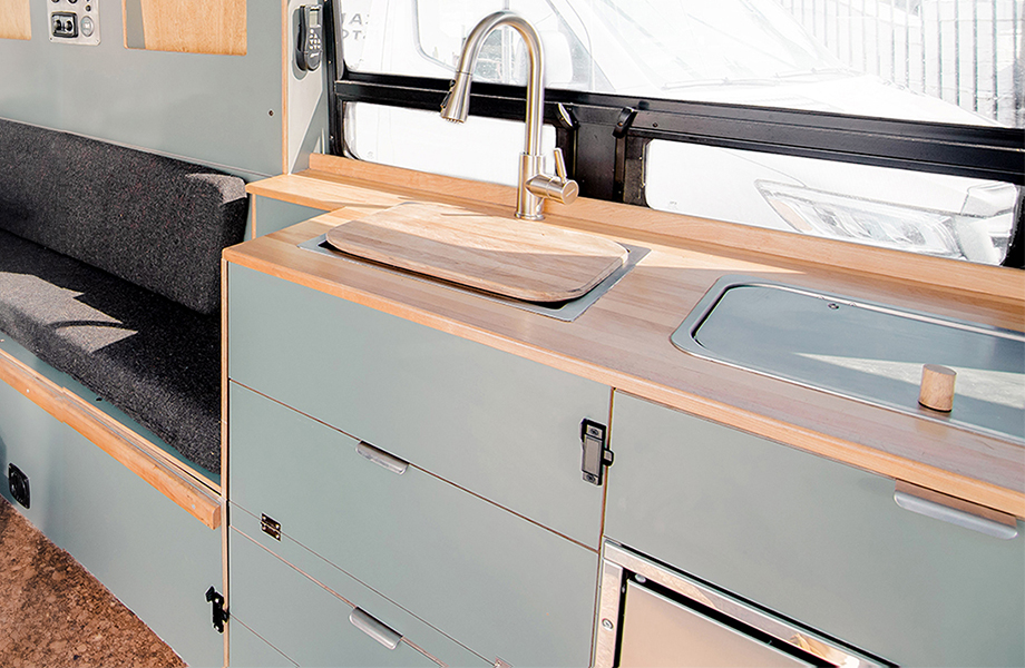 Texino campervan kitchen with light gray FENIX cabinetry, wooden countertops and sink