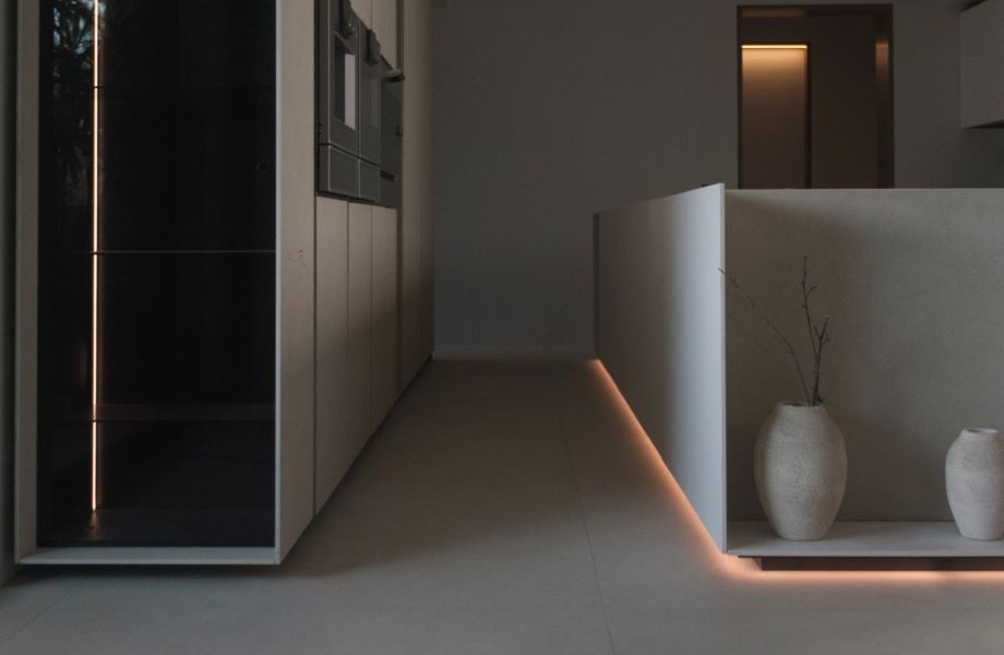 Isla de cocina con FENIX NTM® Bianco Kos y jarrones de adorno