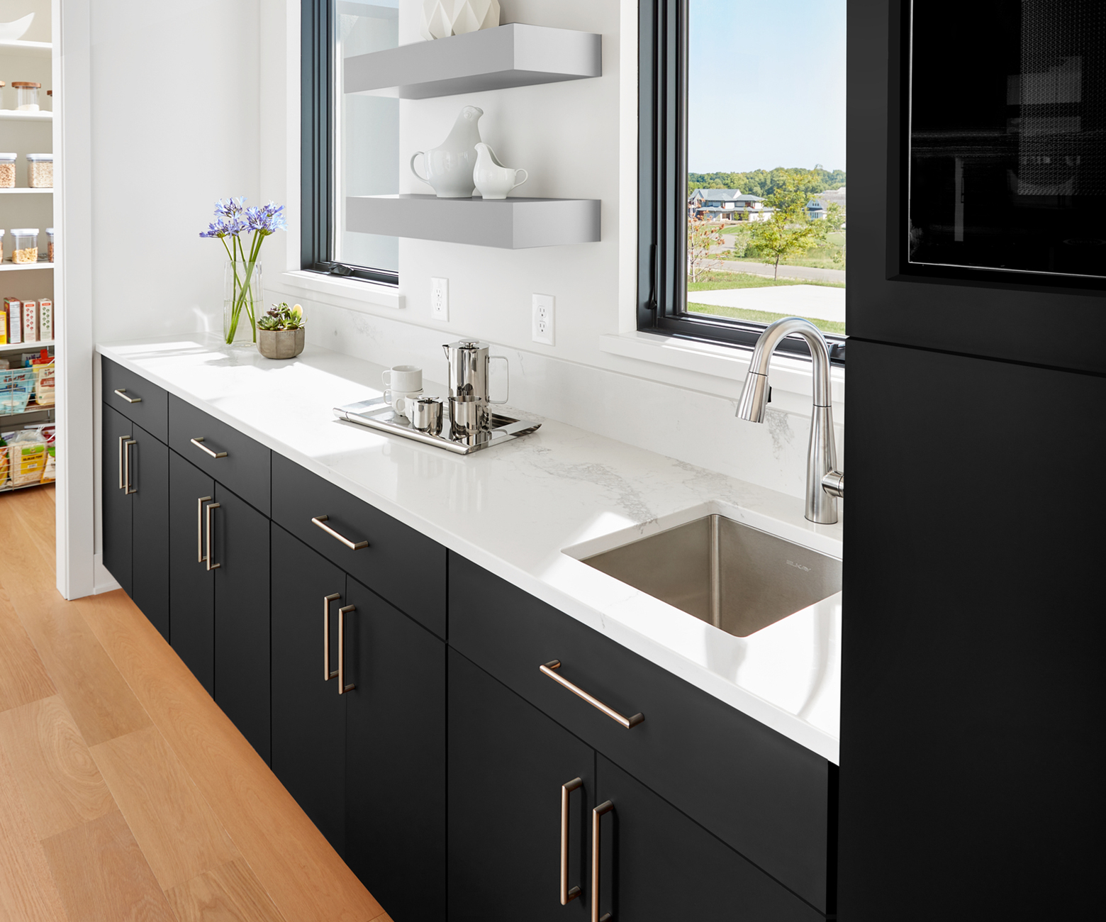 Modern, matte black kitchen cabinets in FENIX NTM Nero Ingo make this tuxedo kitchen a standout. Bonus element: The FENIX NTM Grigio Efeso floating shelf.